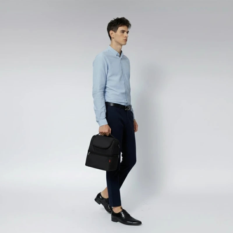 Homme en chemise bleue marchant avec un sac isotherme noir tenu à la main.