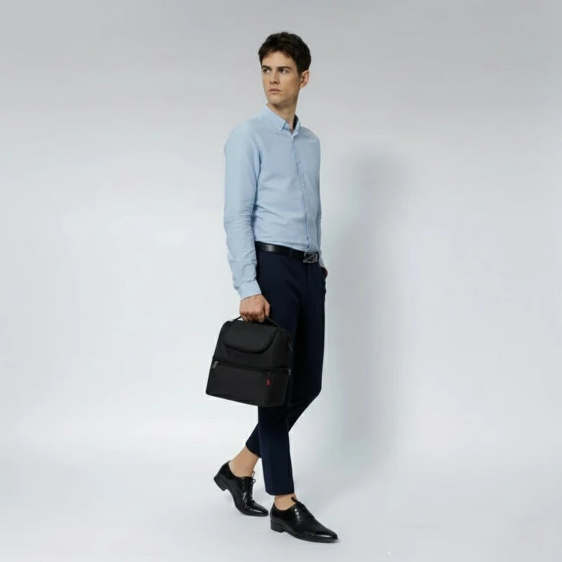 Homme en chemise claire marchant avec un sac isotherme noir tenu à la main.