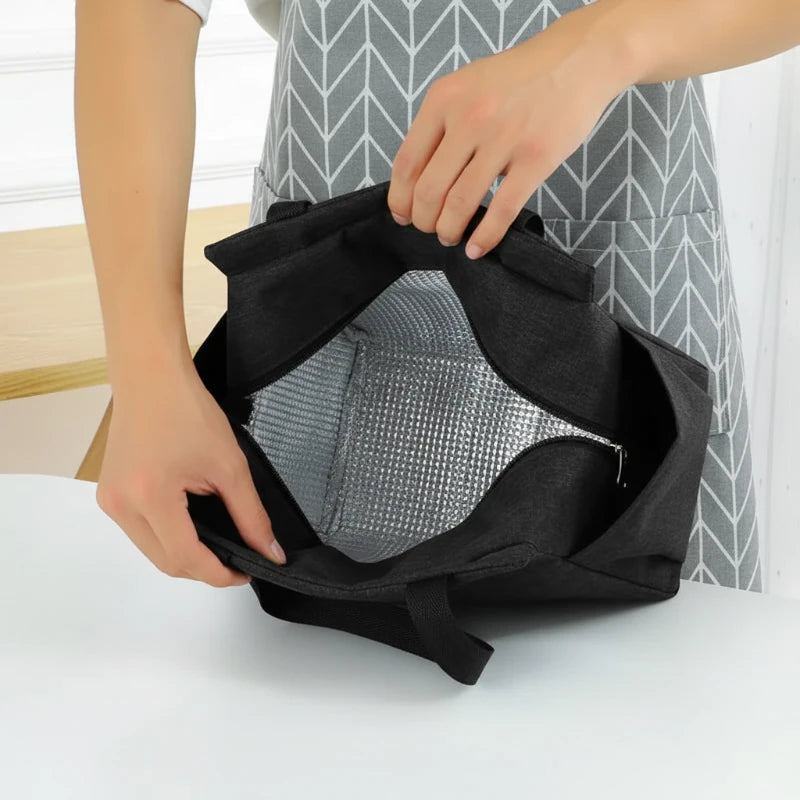 Intérieur d’un sac isotherme noir ouvert, avec doublure aluminium thermique visible, montrant l’isolation pour conserver un repas au frais ou au chaud.