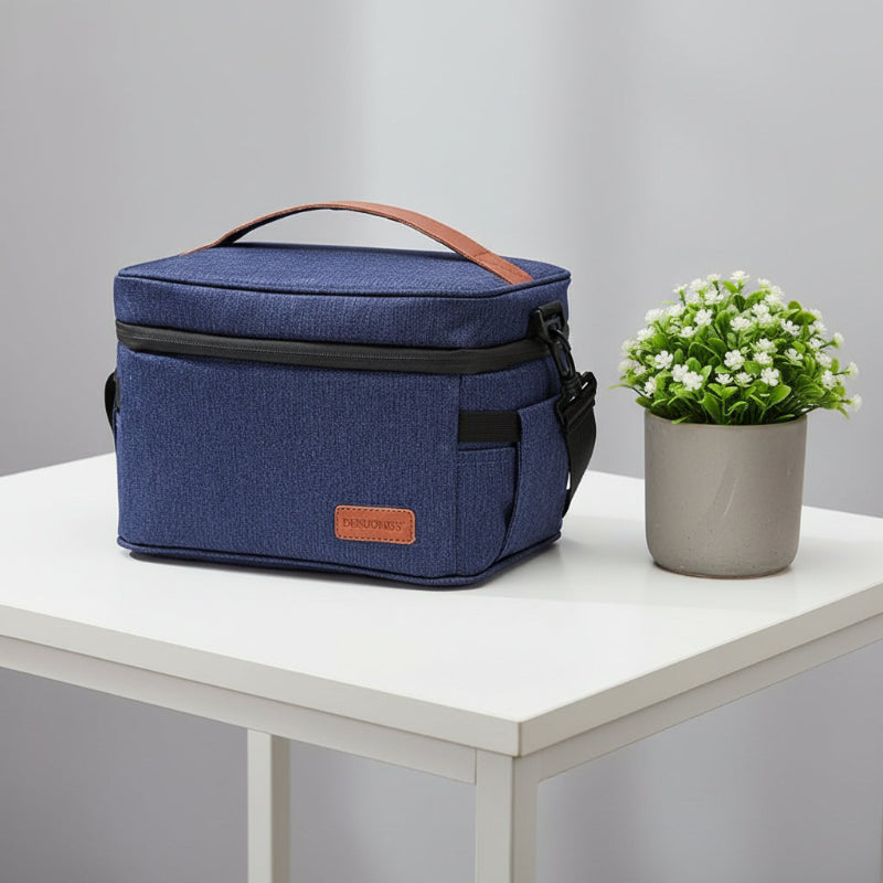 Lunch bag isotherme 7L bleu denim posé sur une table, idéal pour transporter un repas frais au bureau ou en déplacement.