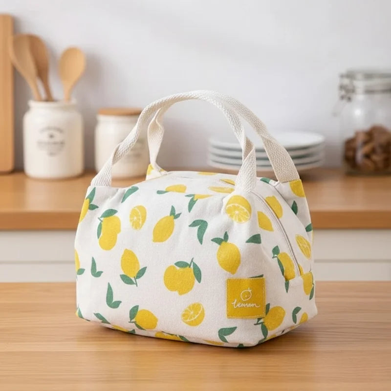 Sac isotherme en toile décoré de citrons et feuilles vertes, parfait pour transporter un repas frais avec style.