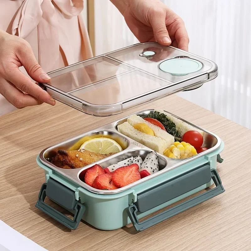 Lunch box isotherme en inox couleur menthe avec trois compartiments et couvercle hermétique transparent, parfaite pour transporter un repas équilibré composé de fruits, légumes, sandwich et viande, tout en gardant les aliments frais et séparés.