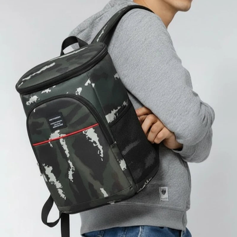 Sac à dos isotherme camouflage porté sur l’épaule, vue de profil, avec poche latérale en maille.