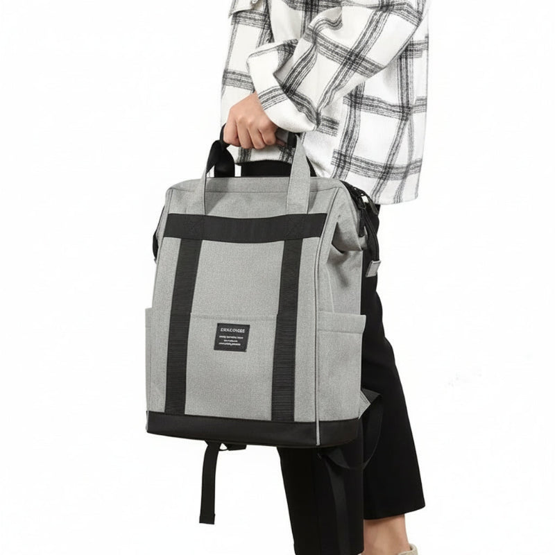 Personne tenant un sac à dos isotherme gris avec détails noirs, présenté en situation pour montrer son format et son style.