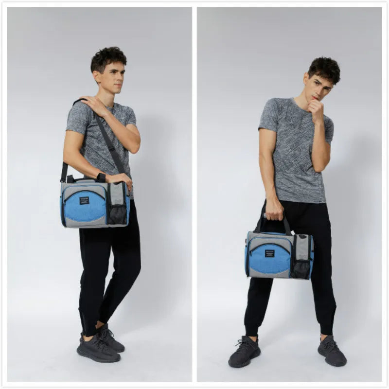Homme portant un sac isotherme 25L gris et bleu uni avec bandoulière réglable et poignées, idéal pour transporter repas et boissons.