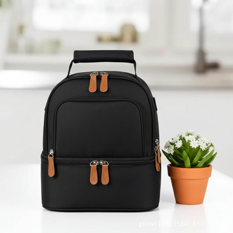 Sac isotherme bébé biberon noir à double compartiment, présenté de face sur une table, format compact adapté au transport du biberon et des repas.
