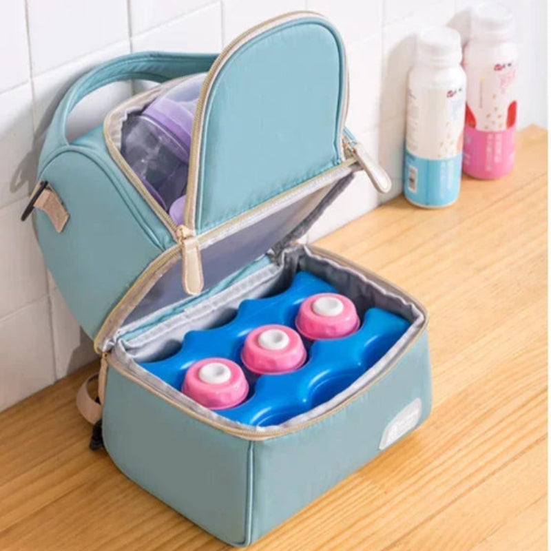 Sac isotherme bébé bleu ouvert contenant des biberons et des accumulateurs de froid, idéal pour conserver le lait maternel pendant les déplacements.