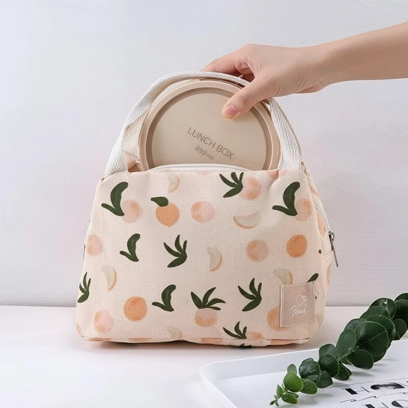 Intérieur d’un sac isotherme beige à motifs pêches, doublé d’un revêtement thermique en aluminium pour une meilleure conservation des repas.