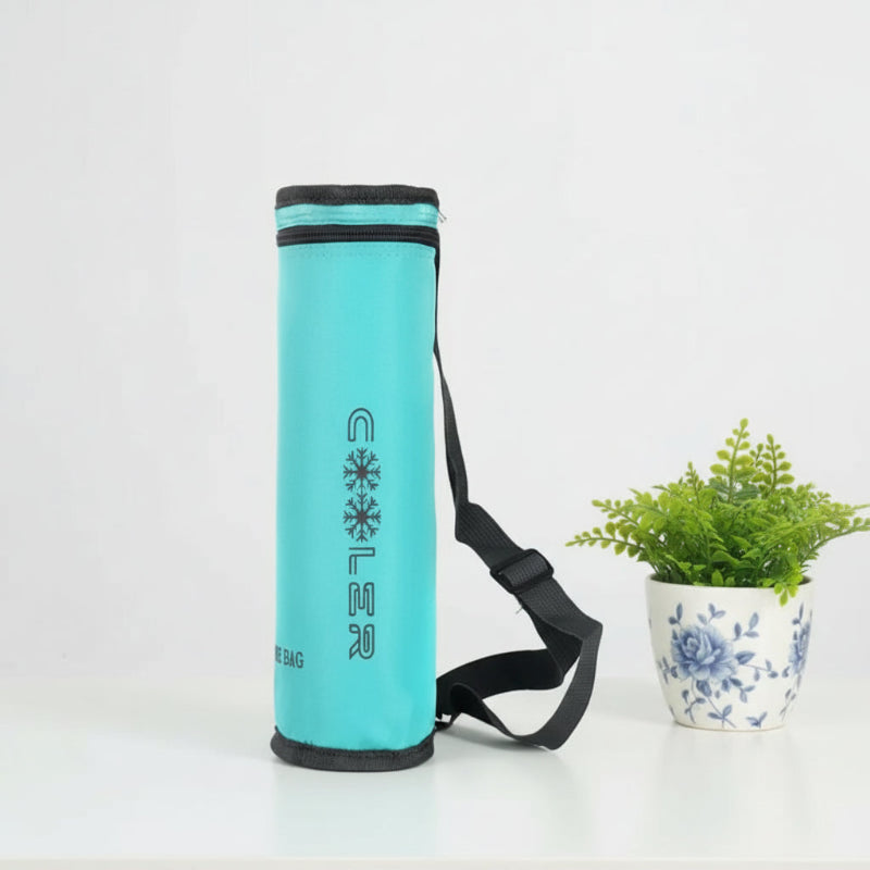Sac isotherme pour bouteille bleu turquoise avec bandoulière, posé sur une table blanche à côté d’une plante.