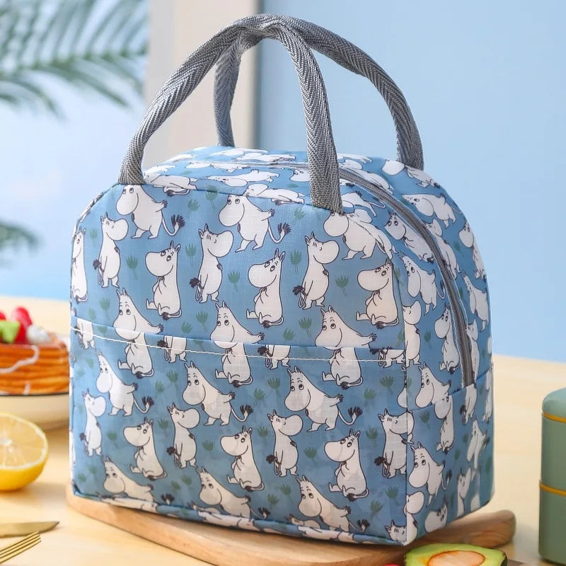 Sac isotherme pour enfant bleu avec motifs d’animaux blancs, posé sur une table en intérieur.