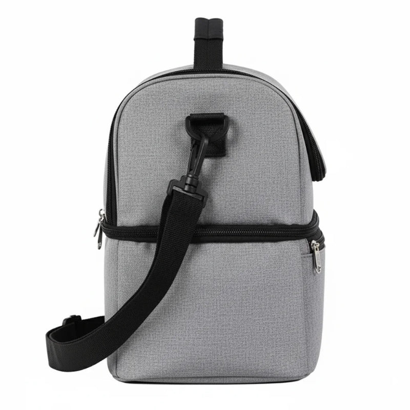 Vue de côté d’un sac isotherme gris à double compartiment, équipé d’une bretelle détachable fixée sur le côté.