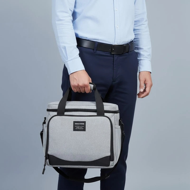 Homme tenant un sac isotherme gris à la main, idéal pour transporter un repas au travail ou lors de déplacements.