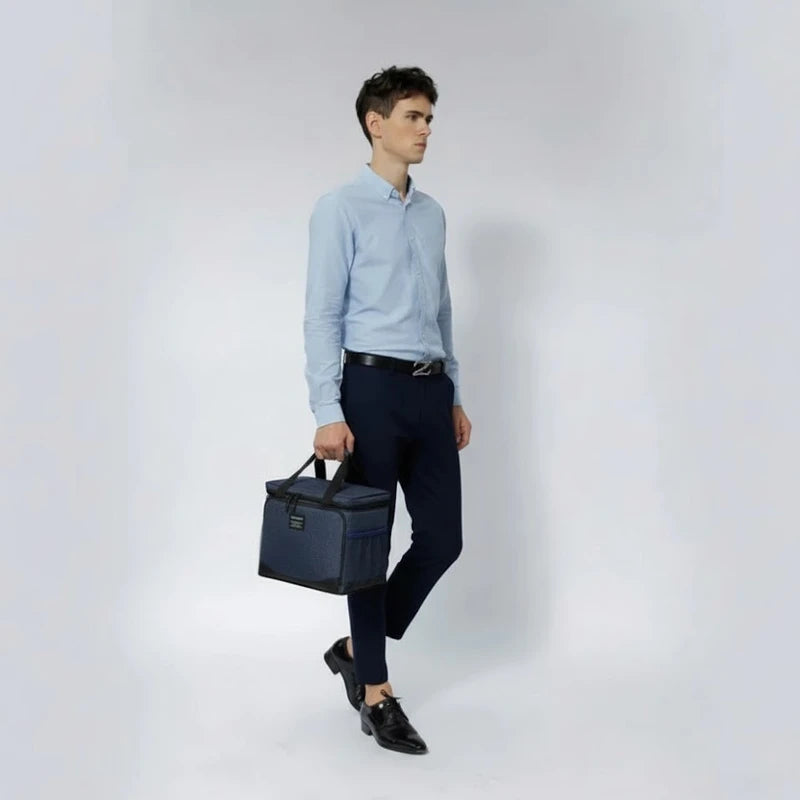 Homme en tenue professionnelle transportant un sac isotherme bleu, idéal pour les repas au travail ou en déplacement.