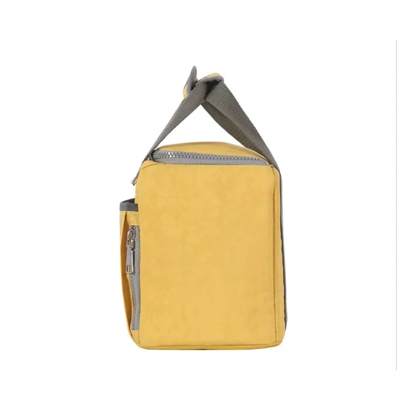 Vue latérale d’un sac isotherme jaune compact, avec poignée grise et fermeture éclair renforcée, idéal pour transporter un repas au quotidien.