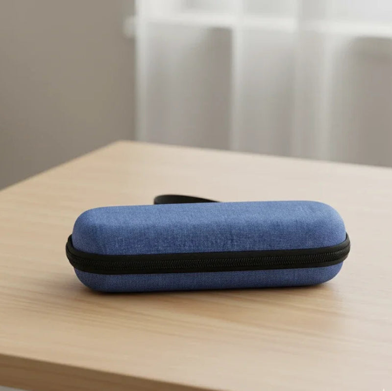 Pochette isotherme médicale bleue en tissu, de forme rectangulaire et rigide, posée fermée sur une table en bois clair, avec une fermeture éclair noire tout autour.