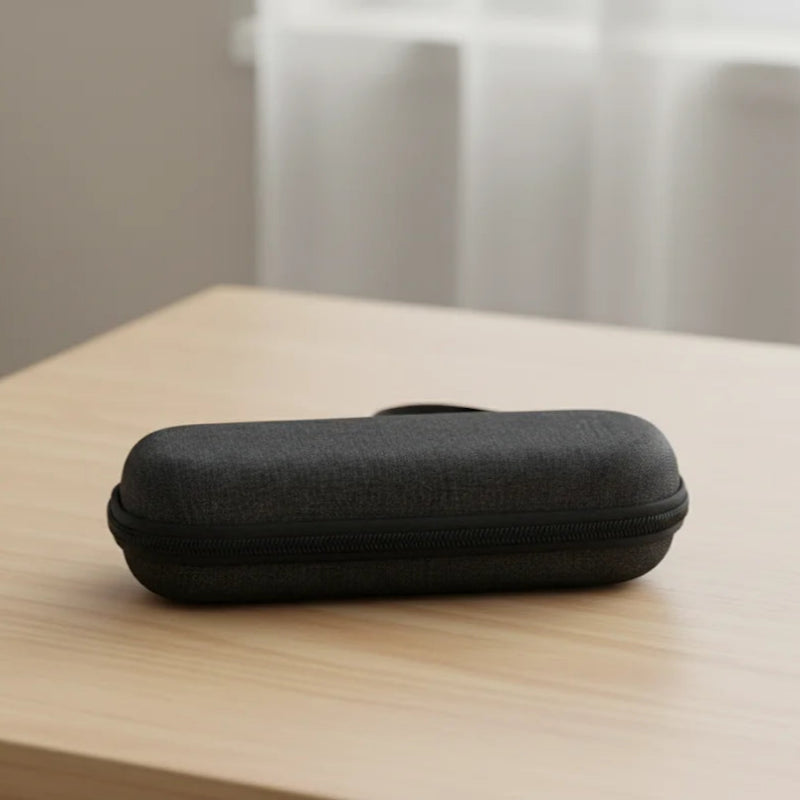 Pochette isotherme médicale noire, de forme rigide et rectangulaire, fermée par une fermeture éclair noire, posée sur une table en bois clair avec un fond flou.