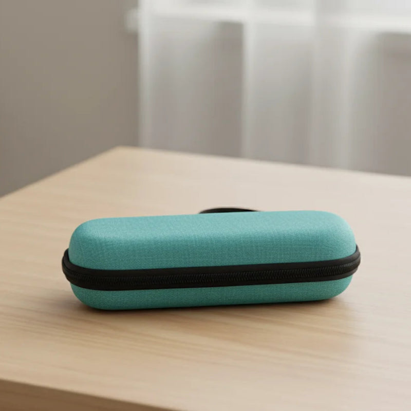 Pochette isotherme médicale verte, de forme rigide et compacte, posée fermée sur une table en bois clair, avec une fermeture éclair noire.