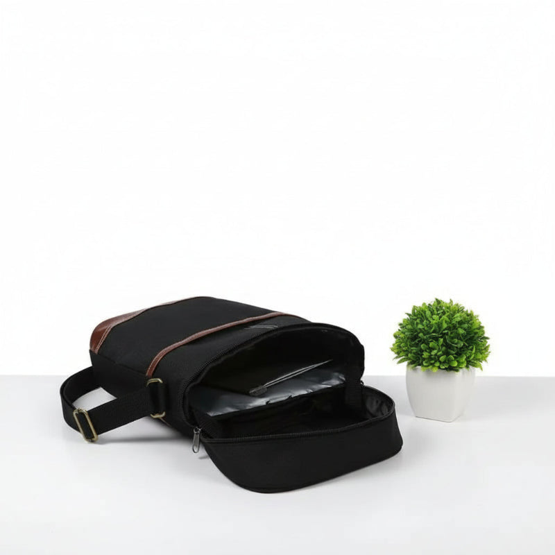 Sac isotherme noir pour bouteille ouvert montrant la poche intérieure isolée, posé sur une table avec une petite plante décorative.