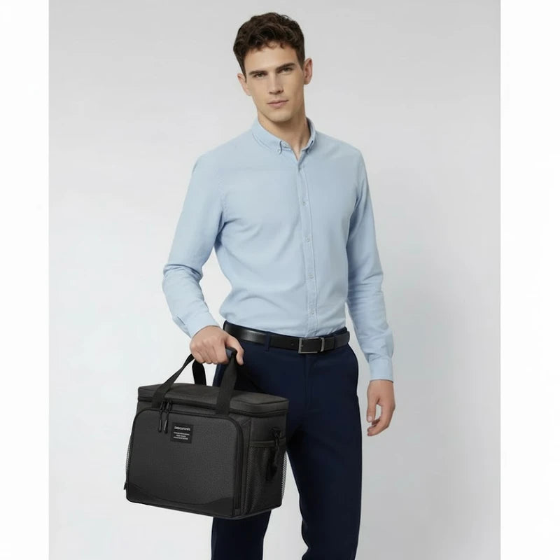 Homme en chemise claire tenant un sac isotherme noir à la main, adapté pour transporter un repas au travail.