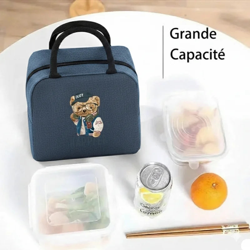 Sac isotherme repas bleu marine, vue de face.
Motif ours marron imprimé, mention “Grande capacité”.
Présenté avec boîtes alimentaires, canette et fruit sur une table.