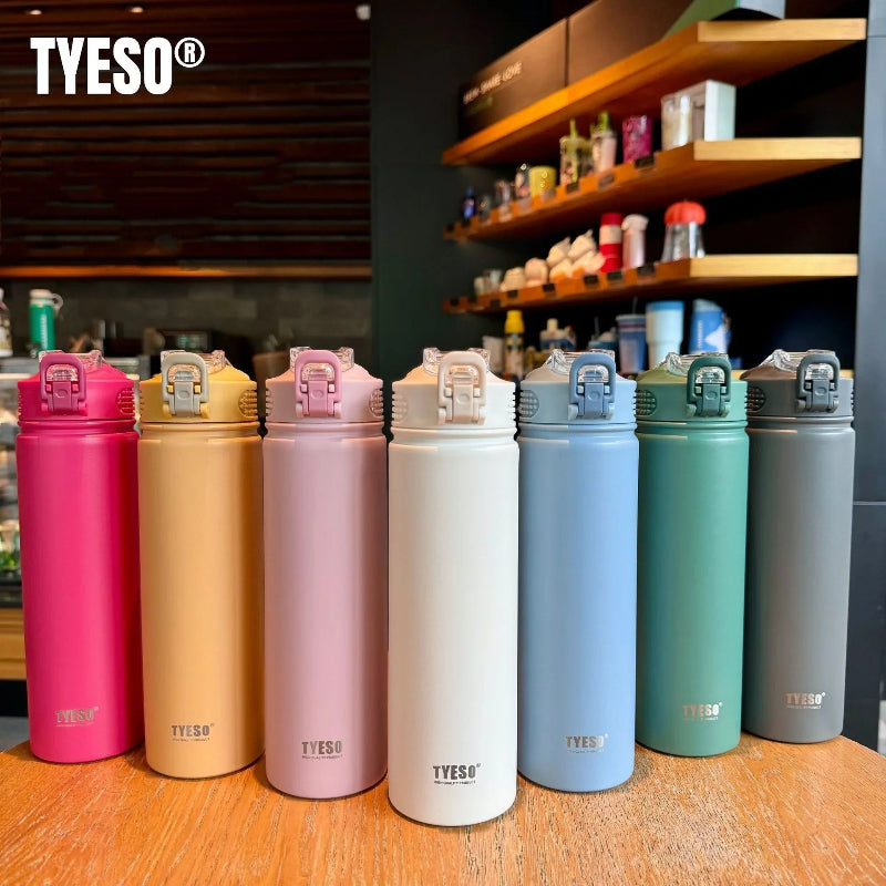Collection de bouteilles isothermes en inox TYESO de différentes couleurs — rose, beige, violet, blanc, bleu, vert et gris — alignées sur une table de café, avec bouchon sport anti-fuite, design élégant et moderne.