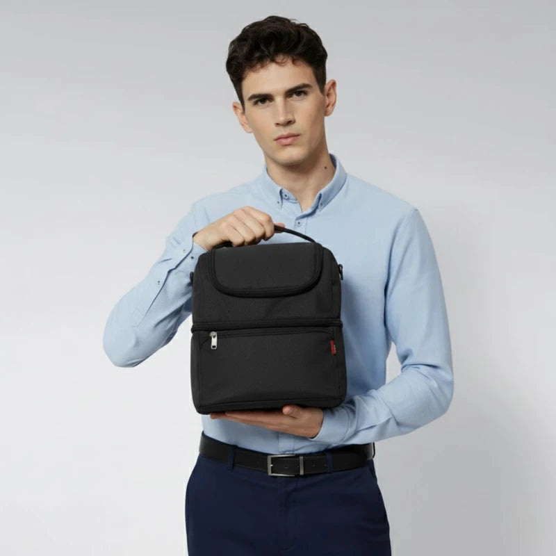 Homme tenant un sac isotherme noir devant lui, présenté de face, en chemise claire.