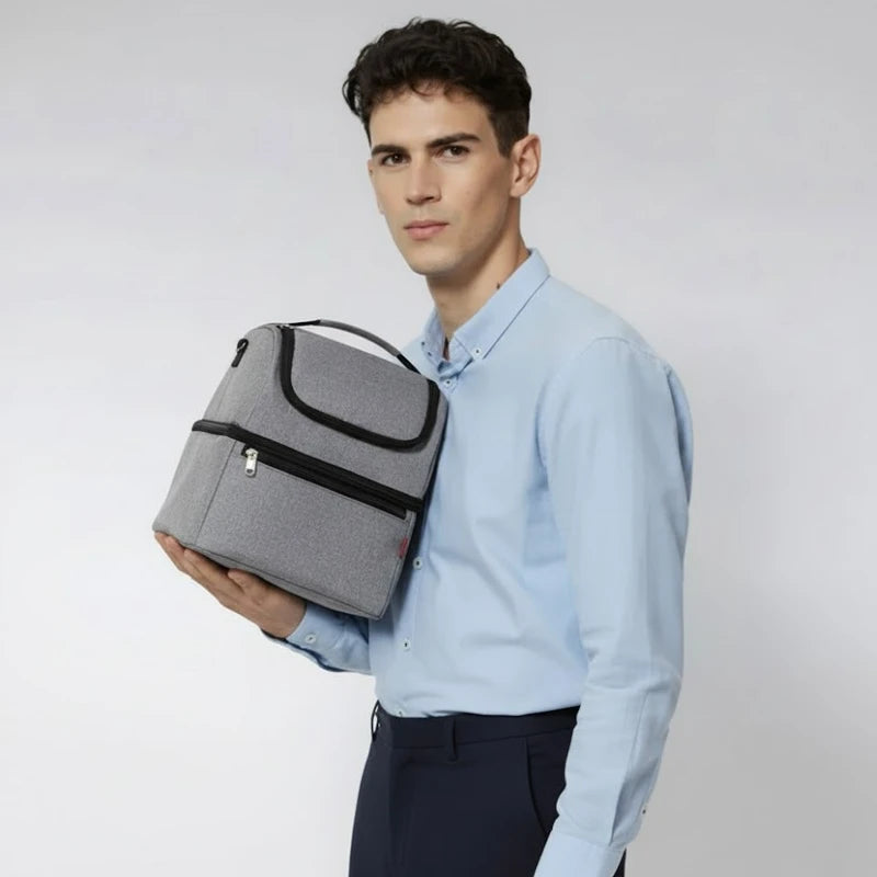 Homme tenant un sac isotherme gris contre l’épaule, en chemise bleue et pantalon foncé.