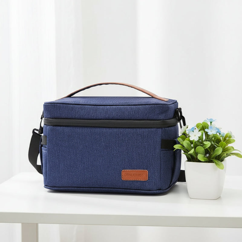 Lunch bag isotherme 7L bleu denim posé sur une table, idéal pour transporter un repas frais au bureau ou à l’extérieur.