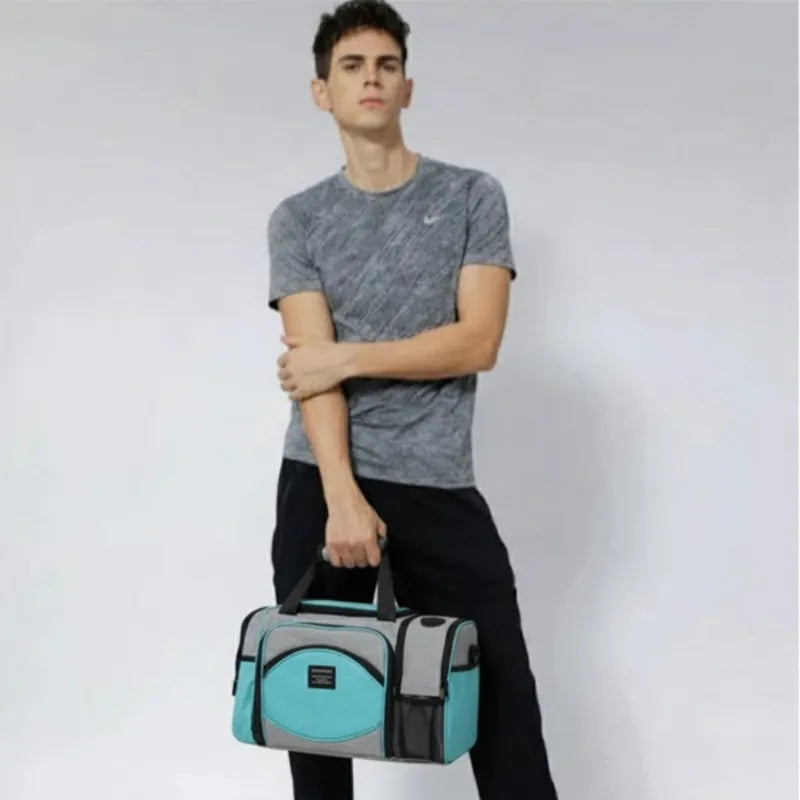 Homme tenant à la main un sac isotherme 25L gris et bleu turquoise uni, idéal pour transporter les repas au bureau, en voyage ou en extérieur.