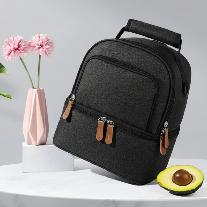 Sac isotherme bébé biberon noir à double compartiment, présenté en vue inclinée sur une table, adapté au transport des repas et accessoires.