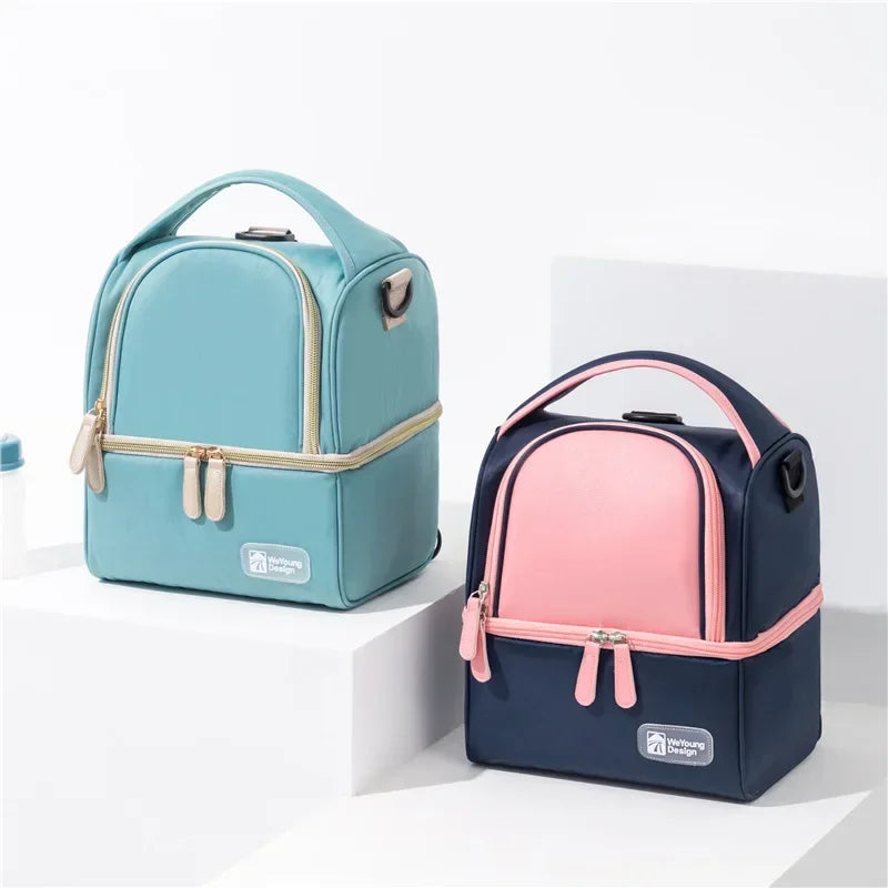 Sac isotherme bébé en bleu brume et bleu rose posé sur un podium, idéal pour biberons et repas lors des sorties.
