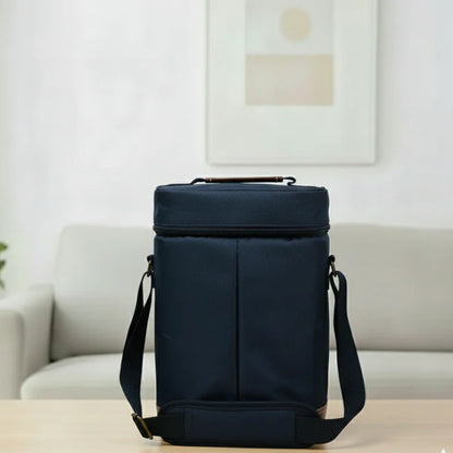 Sac isotherme pour bouteille bleu marine posé sur une table en bois clair de dos dans un salon lumineux.