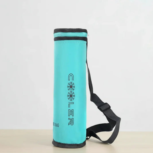 Sac isotherme bouteille bleu turquoise avec bandoulière noire, posé sur une table claire devant un fond blanc épuré.