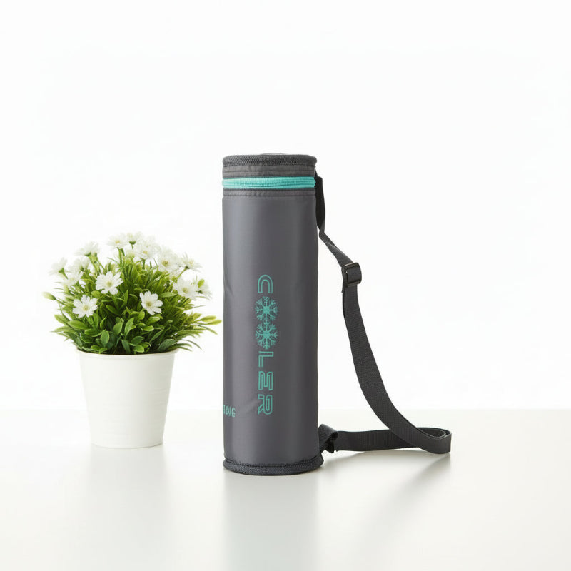 Sac isotherme pour bouteille en gris avec bandoulière réglable, posé sur une table blanche à côté d’une plante fleurie.