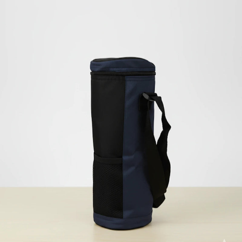 Sac isotherme pour bouteille noir et bleu vu de coter, avec sangle réglable et poche en maille, posé sur une table claire devant un fond blanc.