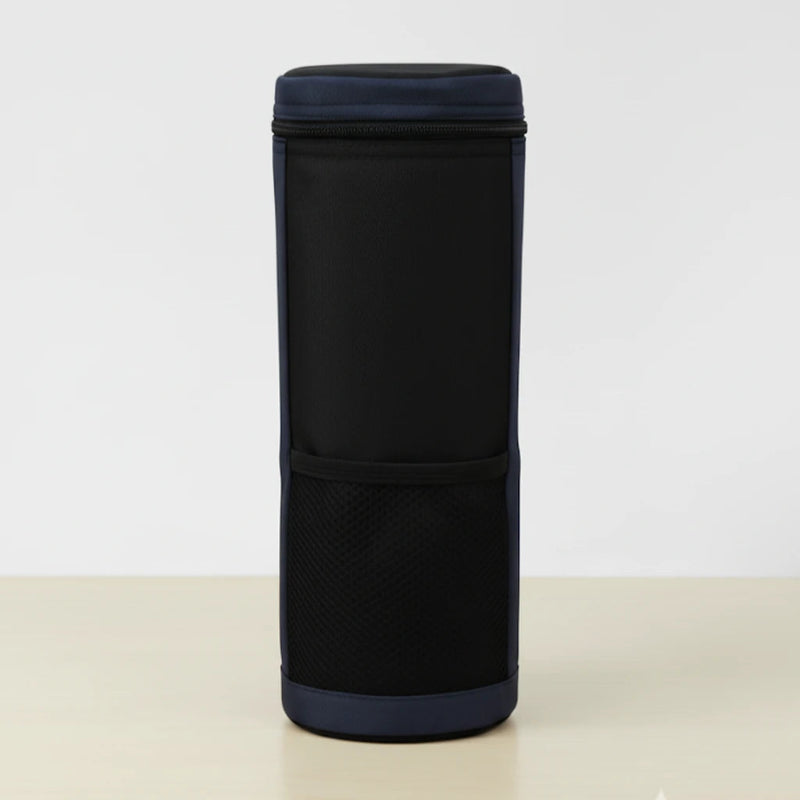 Vue de face d’un sac isotherme pour bouteille noir et bleu, en tissu résistant, avec poche avant en maille, posé sur une table claire devant un fond blanc.