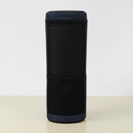 Vue de face d’un sac isotherme pour bouteille noir et bleu, en tissu résistant, avec poche avant en maille, posé sur une table claire devant un fond blanc.