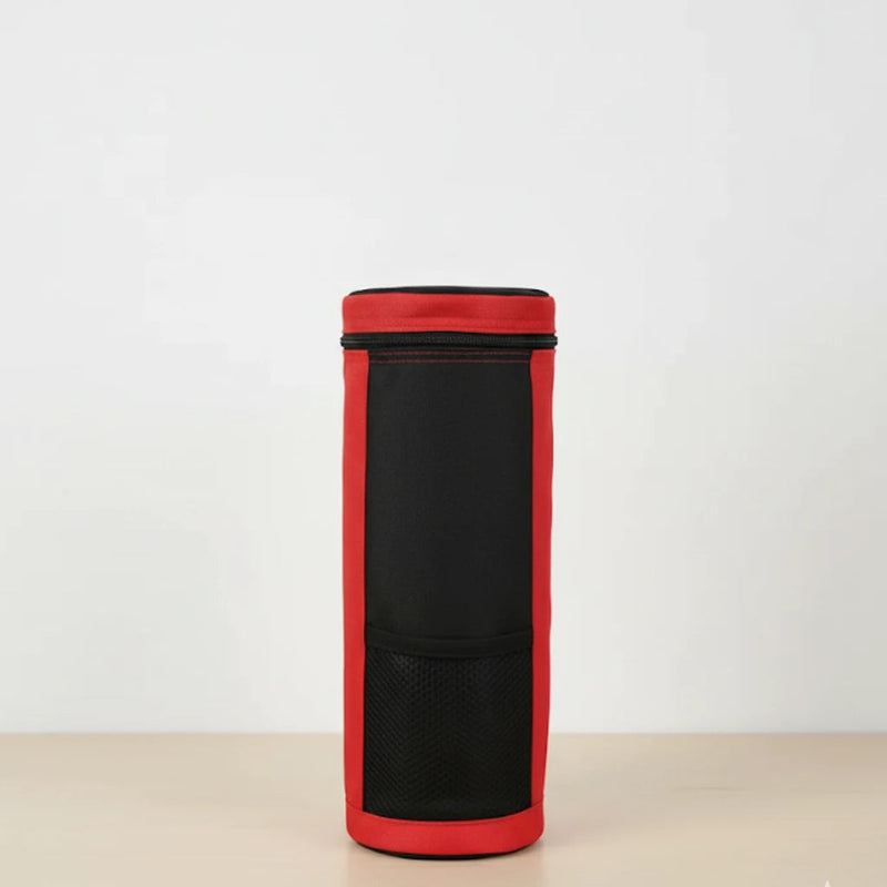 Sac isotherme pour bouteille rouge et noir vu de face, en tissu résistant, avec poche avant en maille, posé sur une table claire devant un fond blanc.