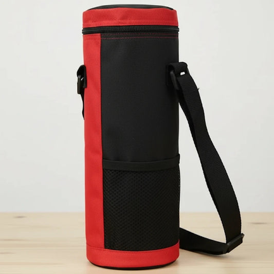 Sac isotherme pour bouteille rouge et noir vu de profil, avec sangle noire ajustable et poche en maille, posé sur une table en bois clair devant un fond blanc.