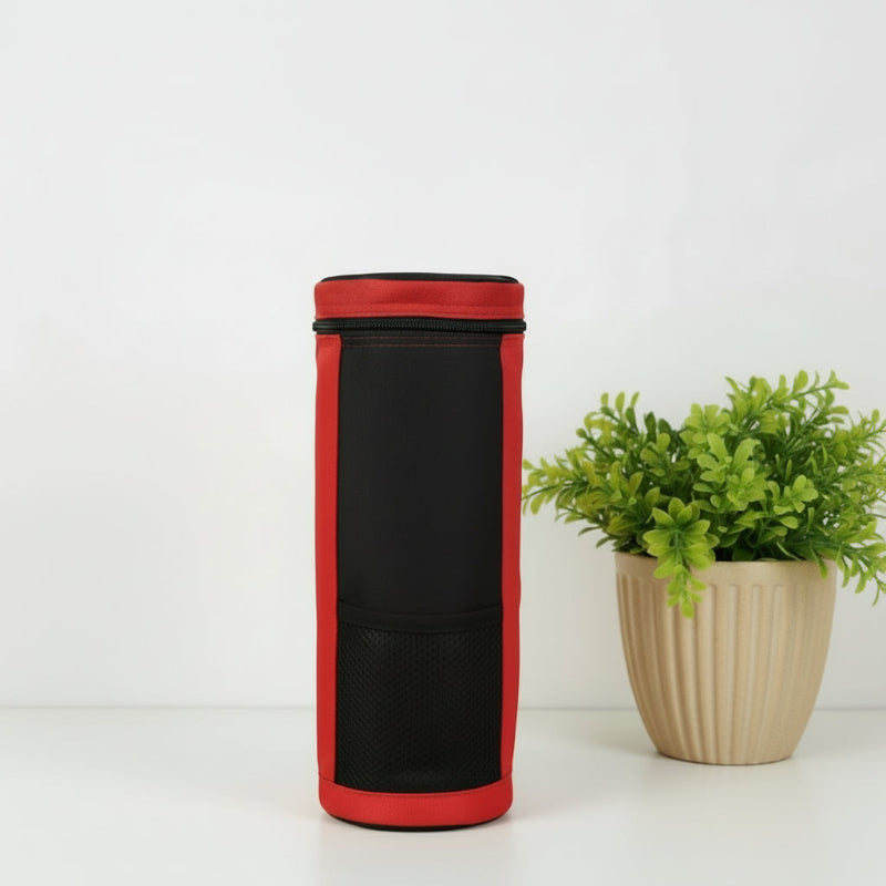 Sac isotherme pour bouteille rouge vu de dos, posé sur une table blanche à côté d’une plante décorative.