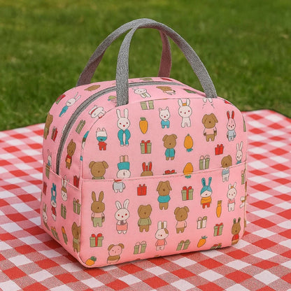 Petit sac isotherme pour enfant rose avec motif lapin poser sur une nape