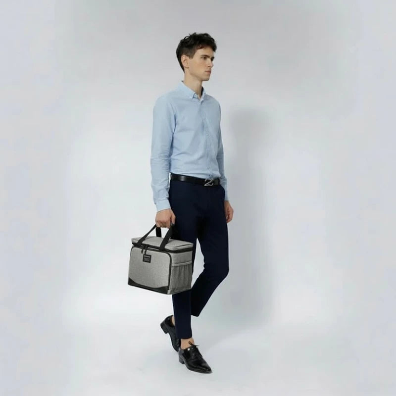 Homme en tenue professionnelle portant un sac isotherme gris, pratique pour transporter un repas au travail ou en déplacement.