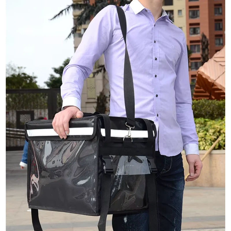 Sac isotherme noir avec parois transparentes, porté en bandoulière par un homme en chemise violette, conçu pour la livraison de repas.