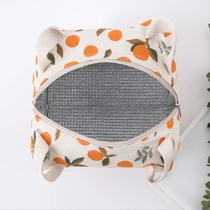 Vue du dessus d’un sac isotherme motif oranges avec doublure intérieure argentée réfléchissante pour maintenir les repas au frais.