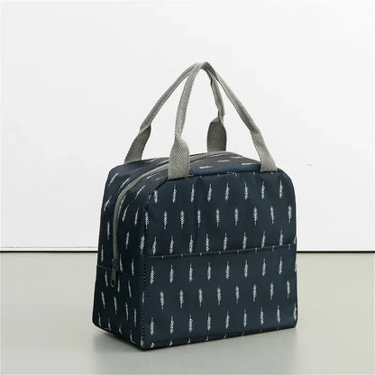 Sac isotherme repas bleu marine vu vu en angle, décoré de motifs blancs en forme de plume.