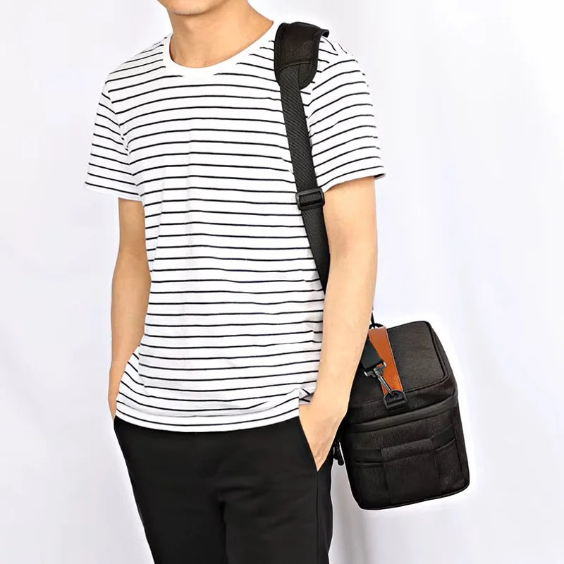 Sac isotherme repas homme noir porté en bandoulière, format compact et pratique pour transporter un déjeuner au travail ou en déplacement
