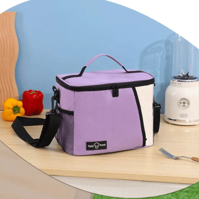Sac lunch isotherme 9L lavande posé sur un plan de travail, avec bandoulière et poches filet pour transporter un repas.