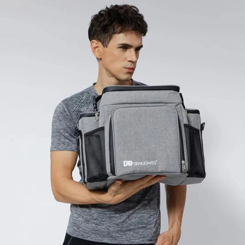 Homme tenant un sac pique-nique isotherme 27L gris, idéal pour transporter repas et boissons lors de sorties.