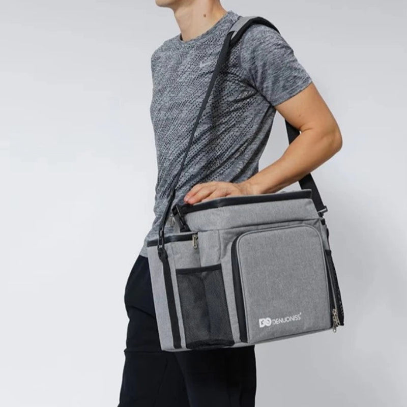Sac pique-nique isotherme 27L gris porté en bandoulière, idéal pour transporter repas et boissons lors de sorties.