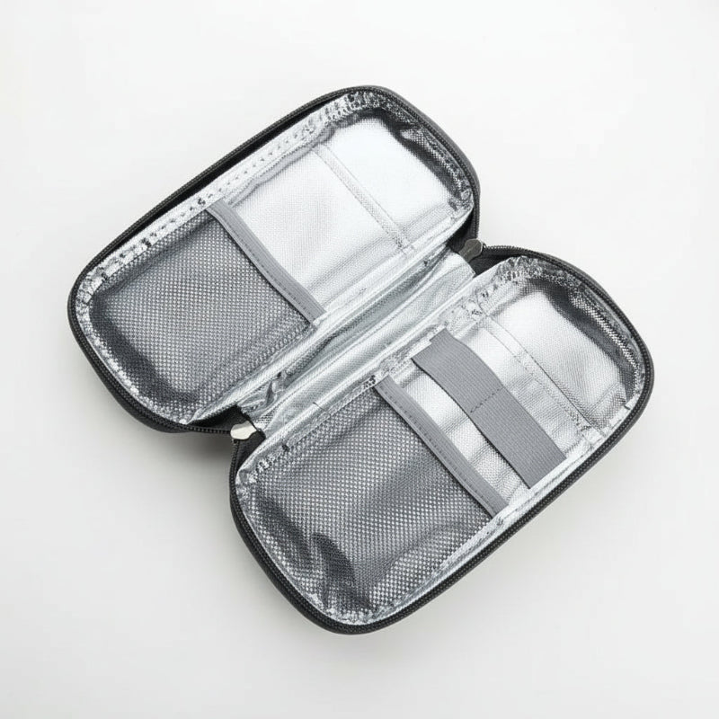 Intérieur d’une trousse isotherme avec doublure thermique argentée, poches en maille et élastiques de maintien, vue ouverte de dessus.